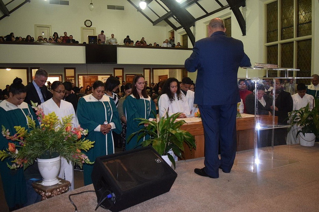 Буйон молится с кандидатами ко крещению в первый Испанской Церкви конференции Огайо в Кливленде. (Visitor)