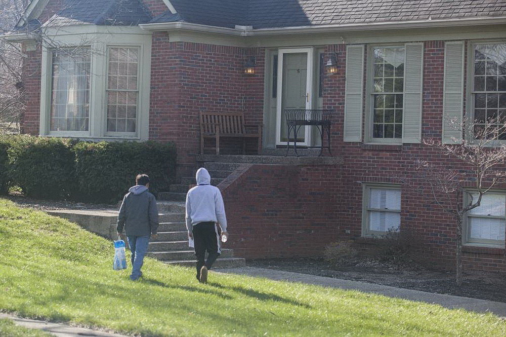 Несколько молодых людей, участников GYC, приближаются к Луисвилльскому дому.