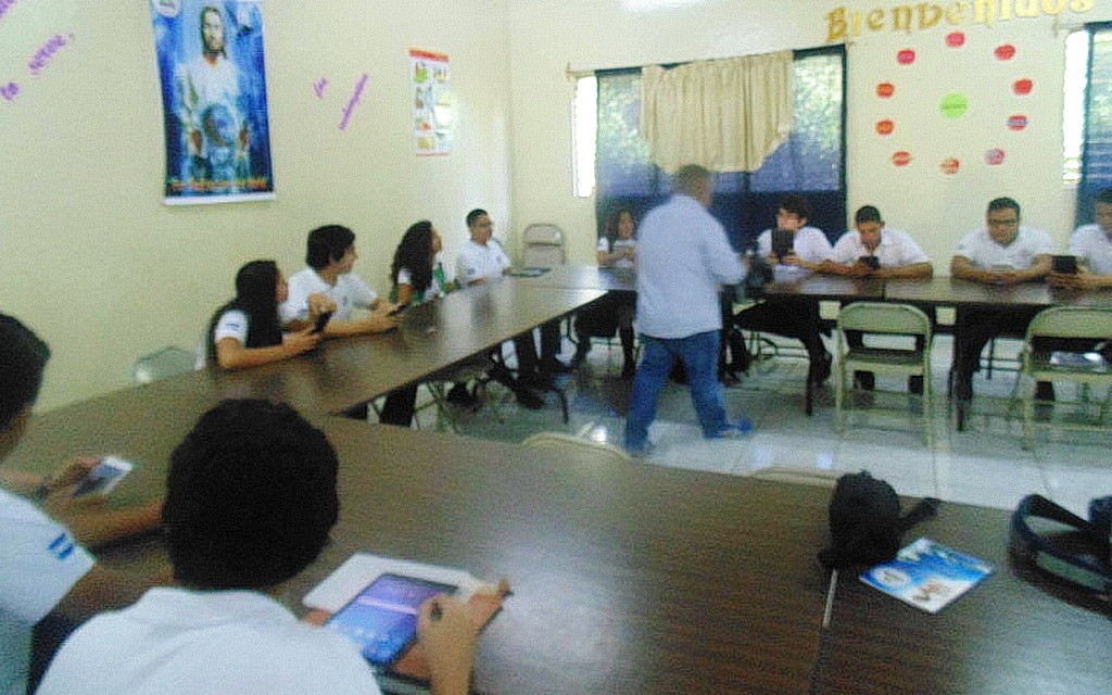Ученики последнего года обучения используют планшеты во время работы в классе.