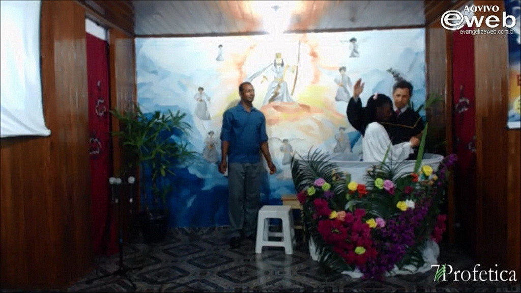 Марсело Флор Дос Сантос, крестящий женщину на евангельской встрече.