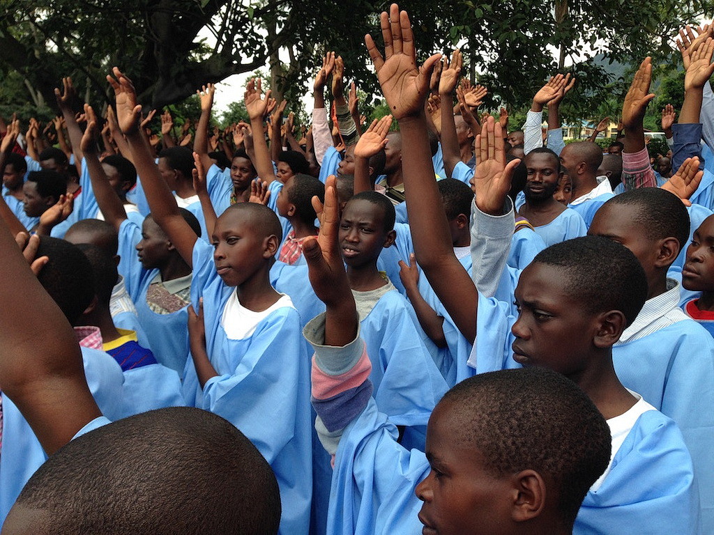 Люди, произносящие исповедание веры перед крещением на берегу озера Киву в субботу.