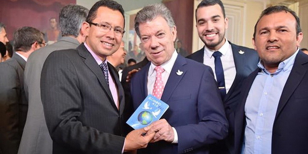 Альваро Ниньо, слева, вручает экземпляр Пути ко Христу” президенту Хуану Мануэлю Сантосу 4 июля 2016 года. (IAD)