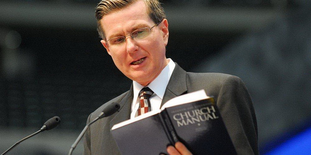 Заместитель секретаря Гомер Трекартин читает Церковное Руководство на Сессии ГК 2010 года в Атланте. (Роберт Ист / ANN)