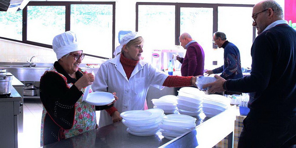 Повары добровольцы кормят гостей во время одного из трех ежедневных приемов пищи, обеспеченных церковью в Риети, Италия. (EUD)