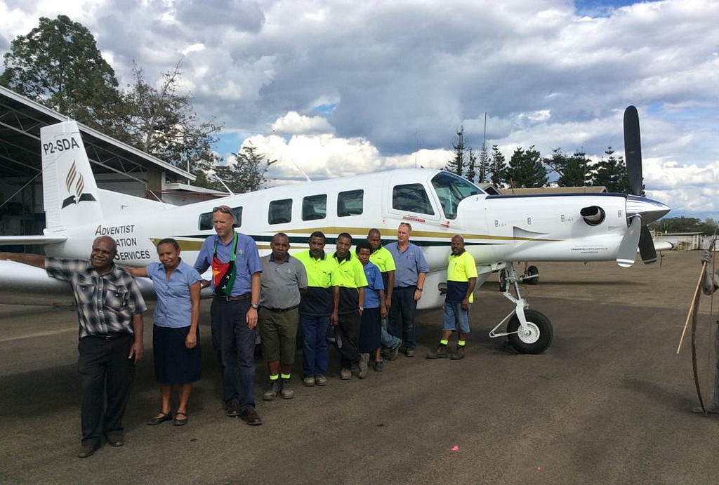 Сотрудники Adventist Aviation Services, позируют рядом с новым P2-SDA.