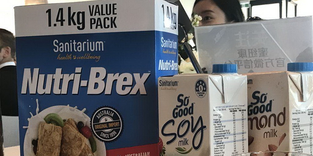 Коробка Nurti-Brex и произведенного «Sanitarium» соевого молока демонстрируется на пресс-конференции. (Трейси Бридкатт / Adventist Record)