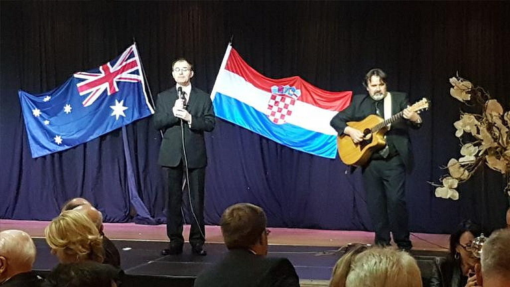 Пастор Эдвард Милер, слева, поет на торжественном ужине под сопровождение гитары Дамьена Радовановича, справа. [Фото: Adventist Record]