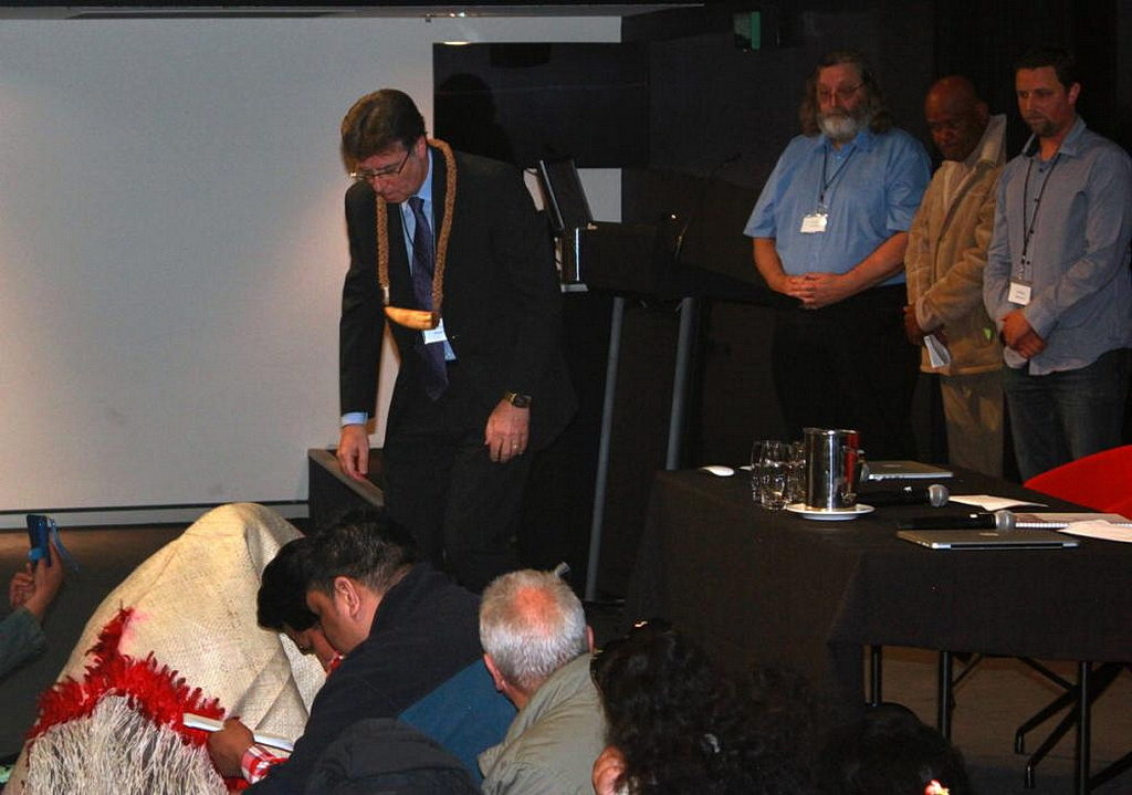 Пастор Майк Фабер, президент Конференции SNSW, носит Табуа и принимает извинение самоанского члена церкви, находящегося под циновкой. [Фото: Adventist Record]