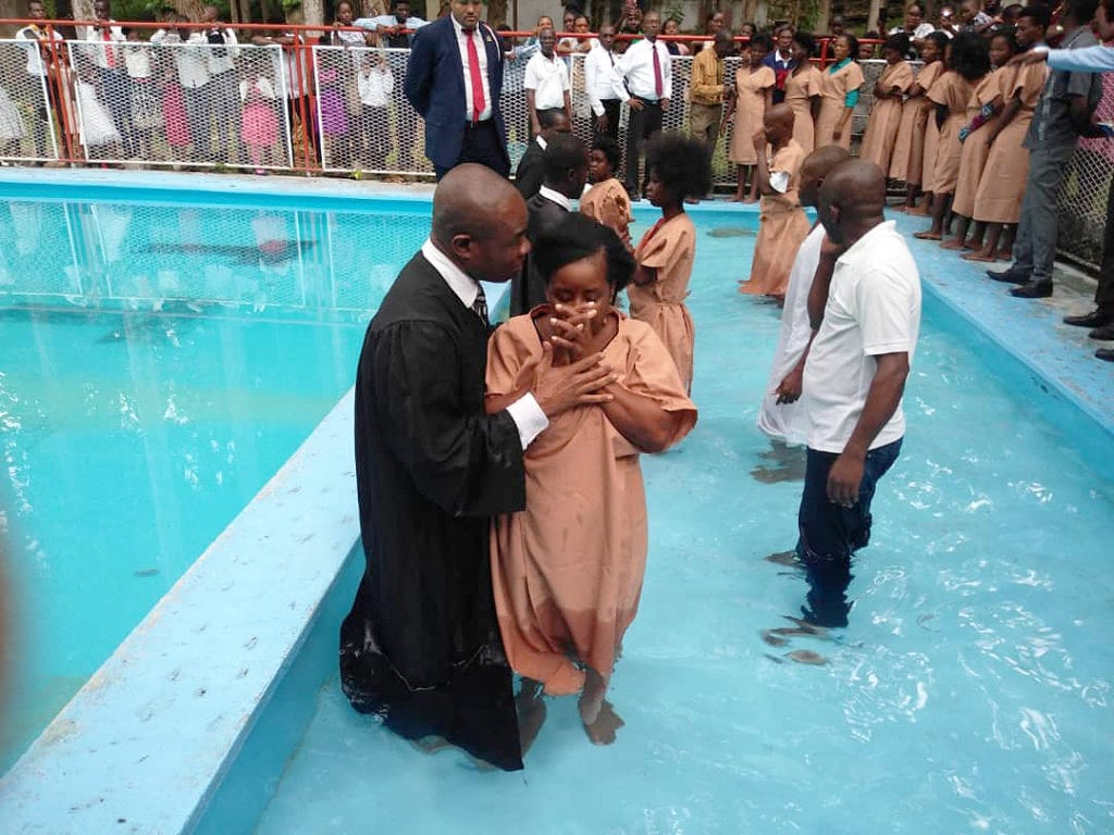 Десятки людей крестились в бассейне на территории кампуса Гаитянского адвентистского университета в Карфуре, Порт-о-Пренс, в апреле 2022 года. [Фото: Гаитянский унион]