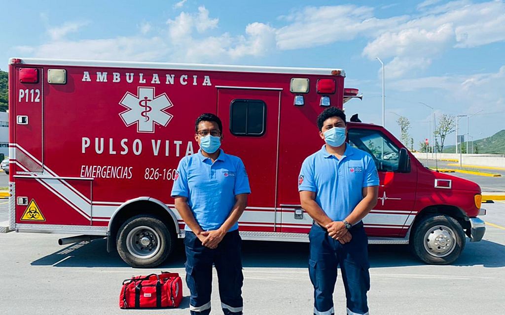 Парамедик Густаво Ривера (справа) стоит перед своей машиной скорой помощи Pulso Vital рядом с коллегой-парамедиком Дидье Паломеком в Монтеморелосе, штат Нуэво-Леон, Мексика. [Фото: любезно предоставлено Густаво Риверой]
